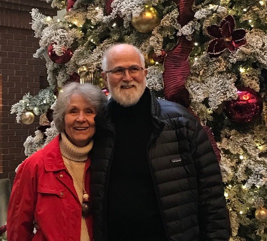 Elderly man and woman in front of a Christmas tree